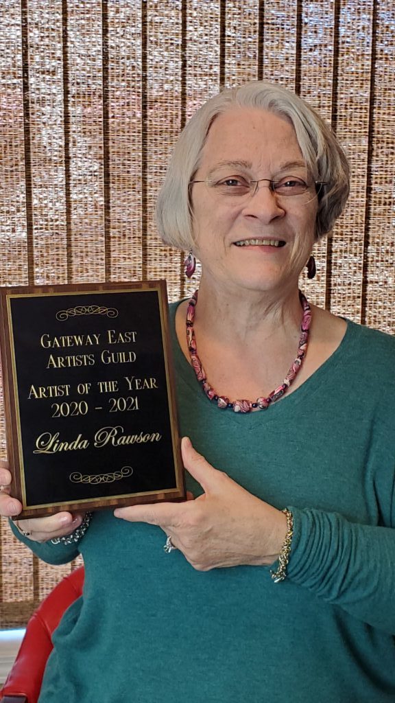 Linda Rawson holding artist of the year plaque